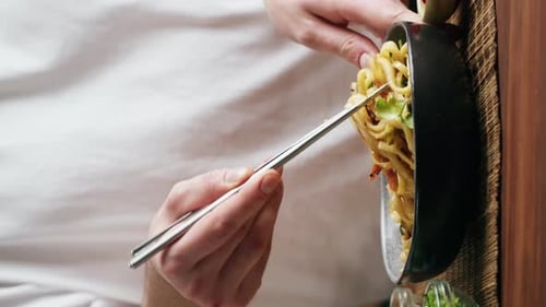 Chef Serves Noodles with Chopsticks Close Up