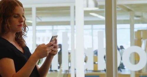 Businesswoman using mobile phone in office 4k