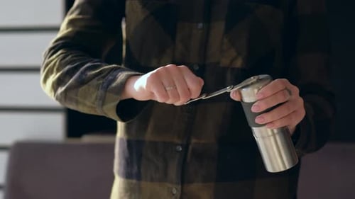 Adult Grinding Coffee Beans with Manual Coffee Grinder