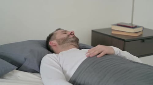 Homme se réveillant d'un cauchemar au lit