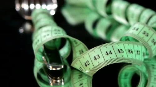 Fork Entangled with Measuring Tape on Reflective Surface