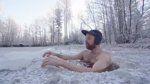 Man Ice Swimming in Frozen Lake in Winter