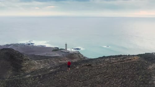 Mann joggt den Bergweg des Vulkans Capelinhos hinunter, Insel Faial, Azoren
