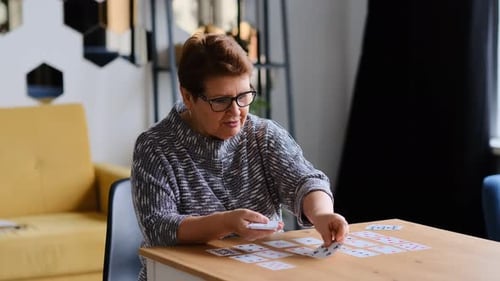 Femme âgée jouant au solitaire à la maison