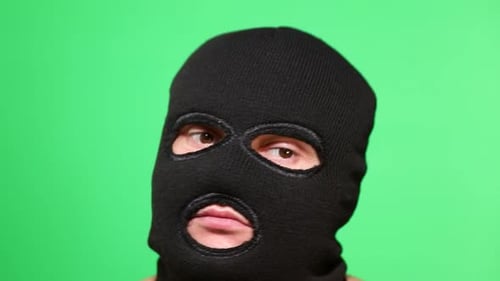 Gruseliger Dieb oder Räuber in Maske blickt in die Kamera