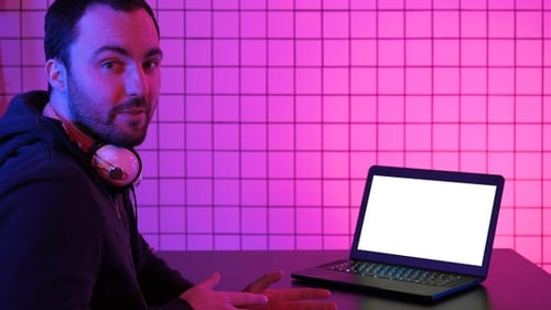 Young Adult With Laptop Talking to Camera