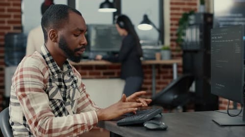 Static Portrait of African American System Engineer Working Focused Looking at Computer Screen