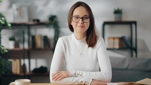 Smiling Woman in White Shirt at Desk