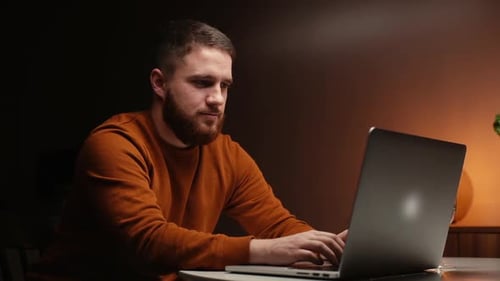 Selbstbewusster Mann benutzt Laptop am Küchentisch