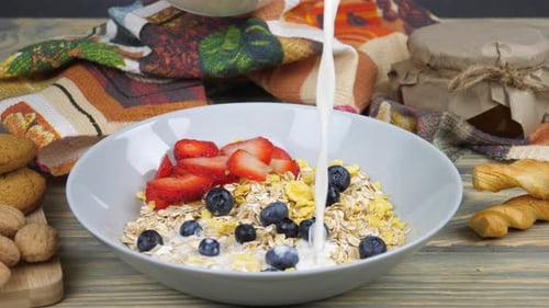 Milk Poured Over Cereal with Strawberries and Blueberries