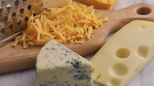 Various Cheeses with Shredded Cheddar and Grater