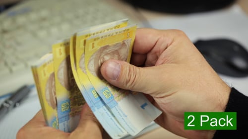 Hands Count Ukrainian Currency Bills in Office