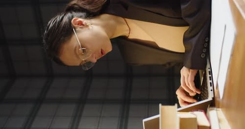 Una mujer trabaja de noche frente a un monitor de computadora portátil