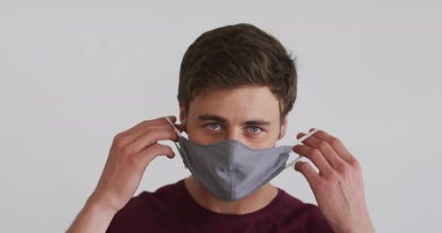 Young Adult Wearing a Gray Face Mask Indoors