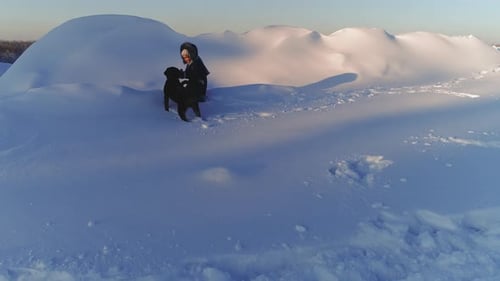 Cheerful Child Playing with Dog in the Snow