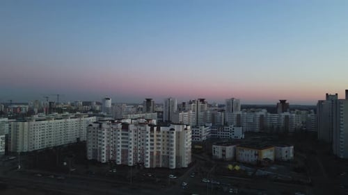 Suburb of a big city. Flight at sunset. High-rise buildings are visible.