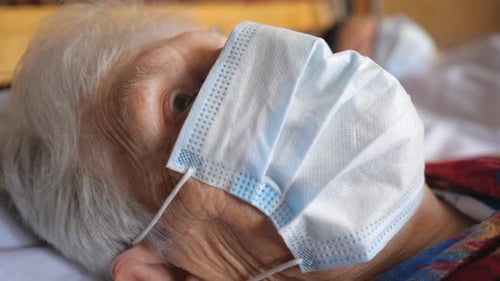 Portrait of Granny Wearing Medical Protective Mask From Virus. Sick Lady with Sad Sight Looking Into