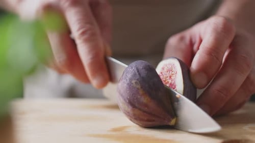 Hands Slicing a Fig on Cutting Board