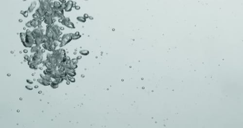 Flüssigkeit wird in Wasser gegossen und erzeugt aufsteigende Blasen