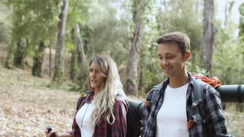 Couple Hiking on Wooded Trail with Backpacks