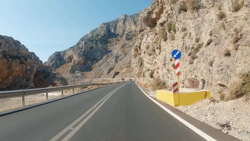 Car driving at sunny countryside route. POV car riding through mountains