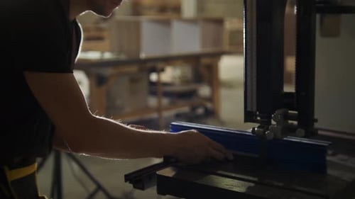 Carpentry Workshop Worker Cutting Wooden Detail Using an Automatic Saw