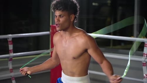 Boxer Jumps Rope in Ring at Night