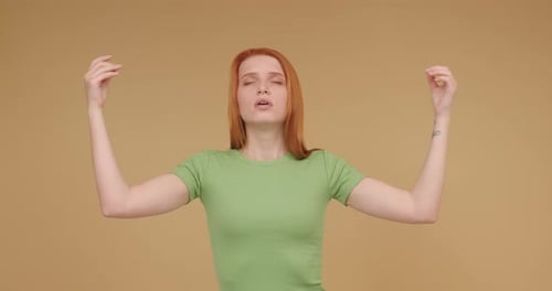 Ginger Woman in Tshirt Meditates Spreading Arms to Calm Down