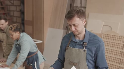 Portrait of Carpenter with Drawing Plan in Woodworking Factory