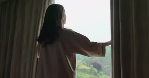 Woman Opens Curtains to Morning Mountain View