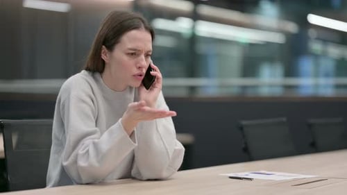 Young Woman Arguing on Mobile Phone in Office