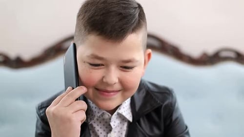 Smiling Boy Talking on Cell Phone Indoors