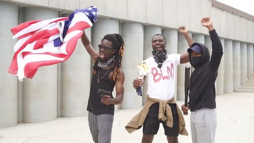 Three Young Adults Posing with Flags and Weapons