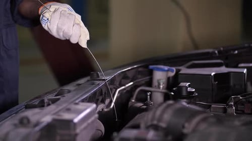Hände des Mechaniker bei der Überprüfung des Motorölstands