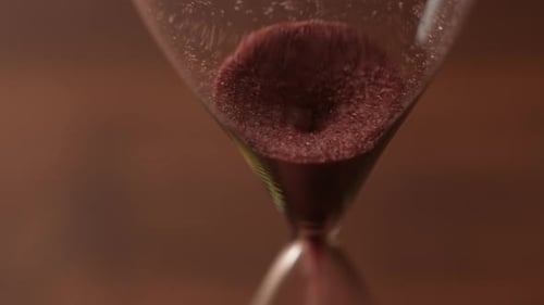 Red Powder Flowing in a Hourglass Close Up