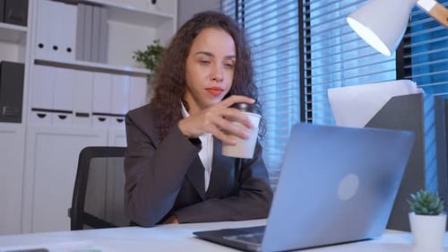 Exhausted Latino business woman using laptop computer work in office.