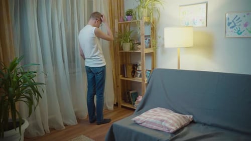 Einsamer süßer Kerl mit Brille zu Hause benutzt Smartphone