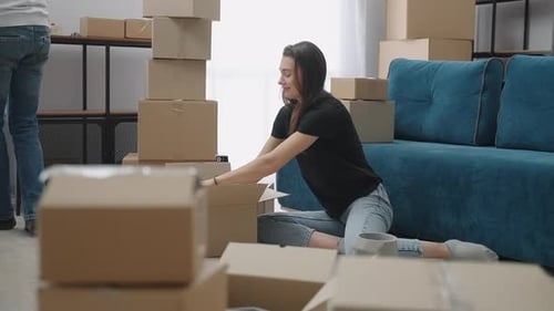 Woman Packing Moving Boxes in Sunny Home