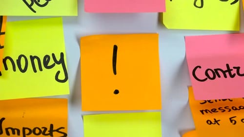 Hand Placing Exclamation Memo Note Among Colorful Sticky Notes