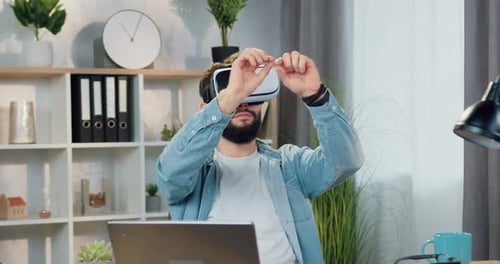 Man Experiences Virtual Reality Headset at Desk