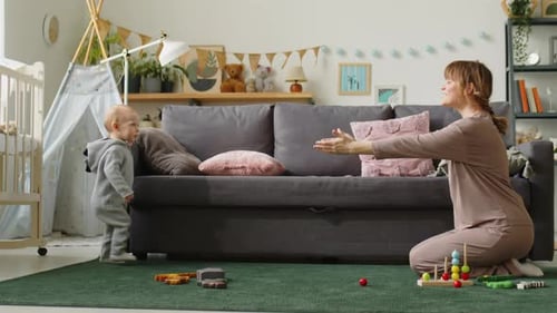 Mother Encourages Baby's First Steps in Sunny Home