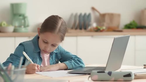 Girl Studies at a Laptop in a Home