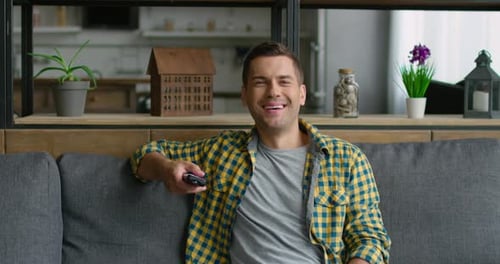 Man Relaxing on Couch with Remote Control