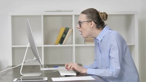 Woman Reacting with Shock While Typing at Computer