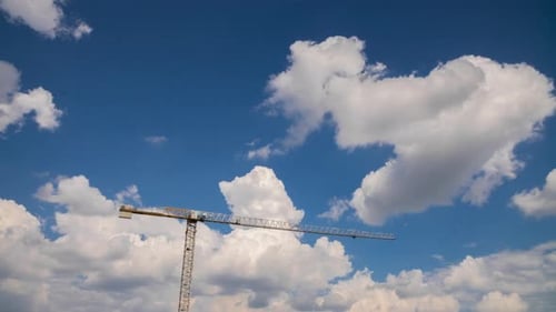 Tower Crane on Construction Site, Moving Clouds in Blue Sky Sunny Summer Day