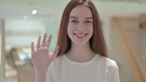 Smiling Woman Waves Hello at Camera