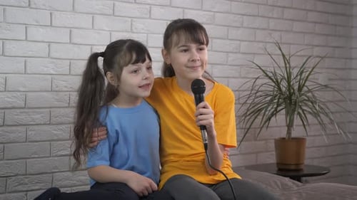 Happy Girls Singing Together into Microphone at Home
