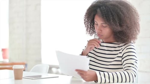 Woman Reviews Documents at Bright White Desk