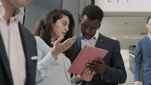 Business Colleagues Reviewing Tablet in Modern Office