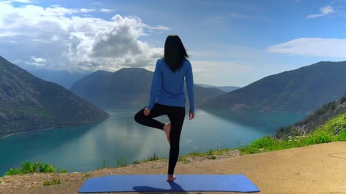 Belle fille faisant du yoga sur la falaise